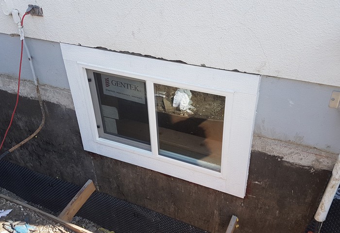  Egress window installation on residential property wall
